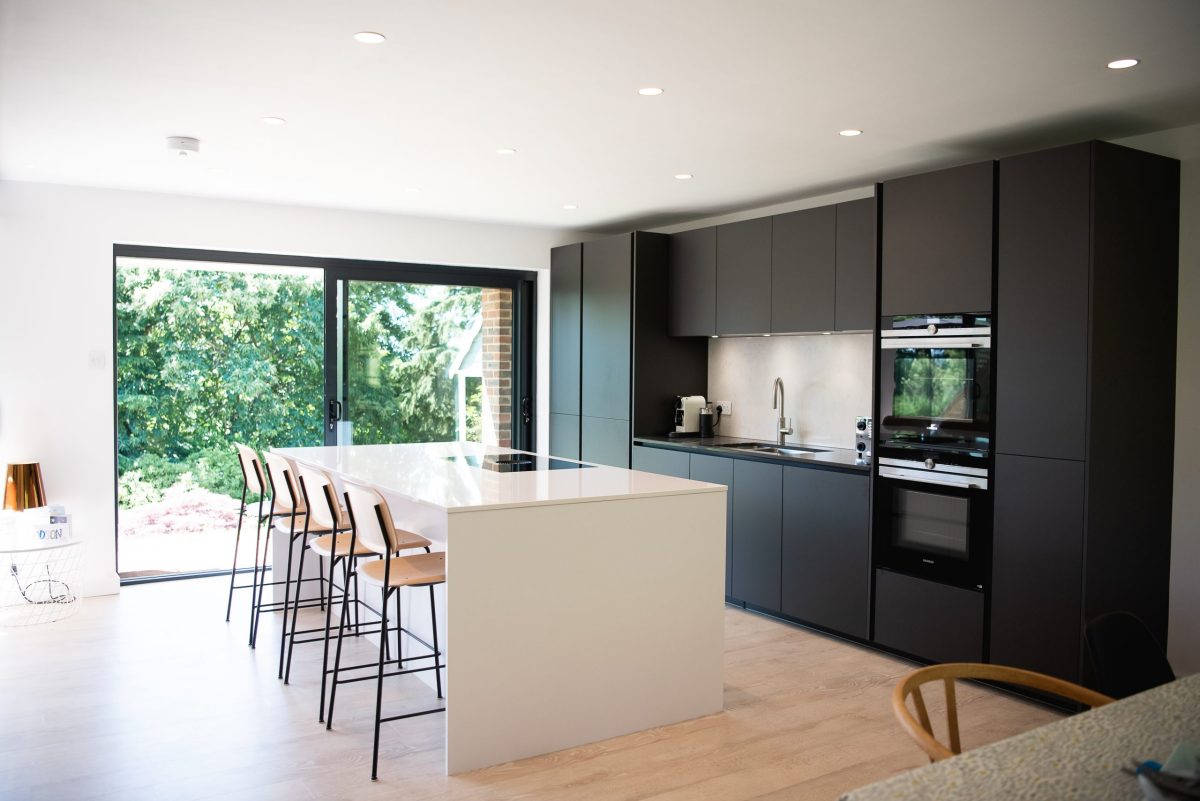 Grey and white handleless kitchen extension with island breakfast bar