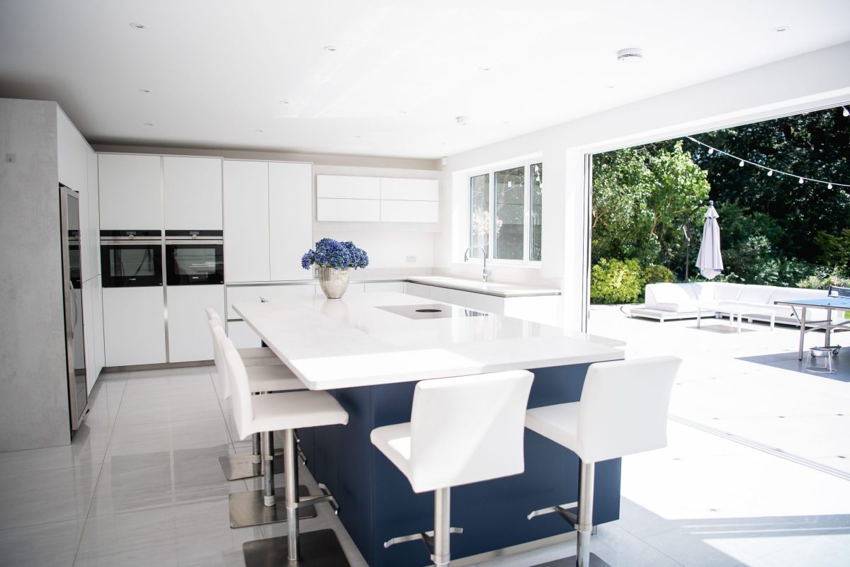 White kitchen extension with blue island with breakfast bar