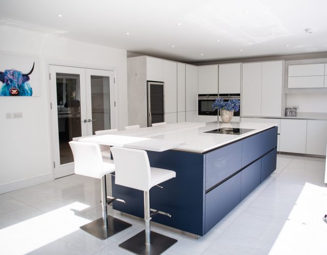 White kitchen with blue kitchen island and Bora hob